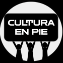 Logo Cultura En Pie: círculo blanco sobre fondo negro. Tres siluetas negras sosteniendo el rótulo negro con las letras blancas dentro del círculo.